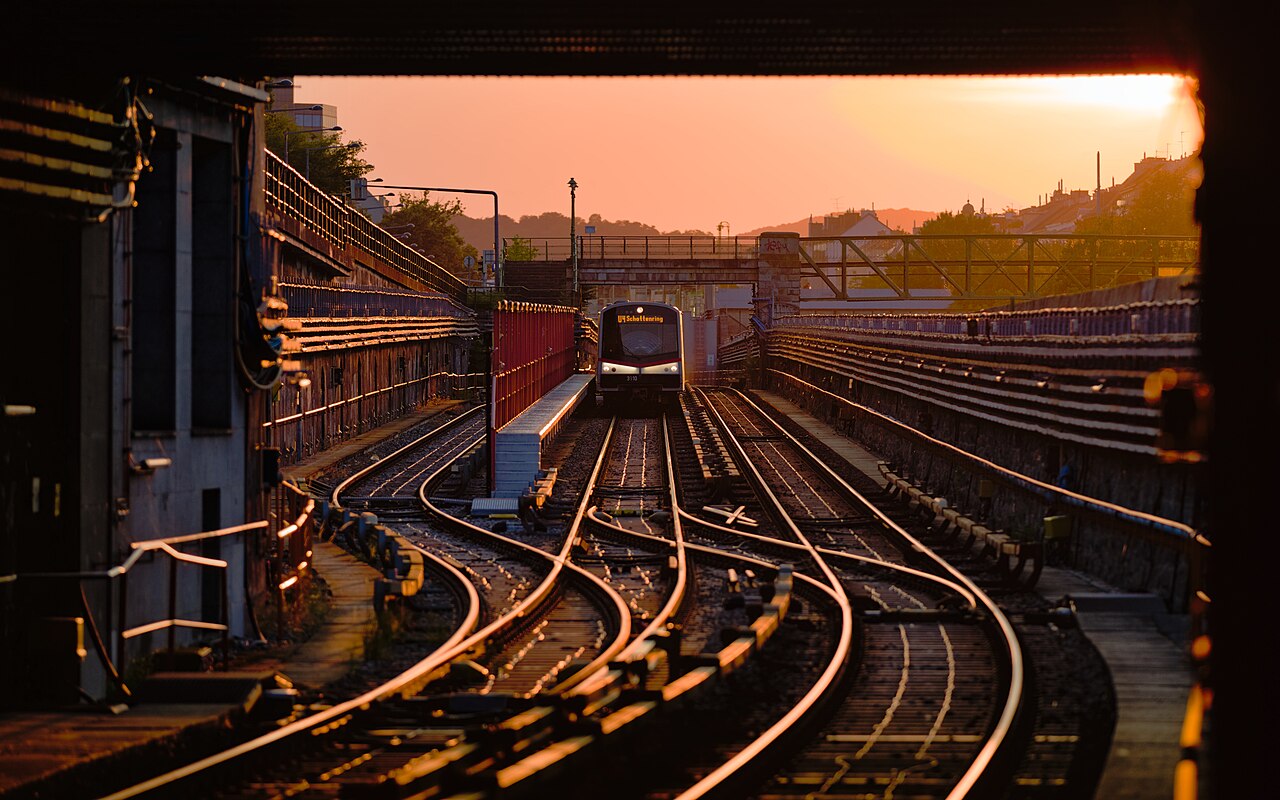 The rails of the U4 metro line with a Type V train ( Vienna U-Bahn ) west of Hietzing station during golden hour in Vienna , Austria